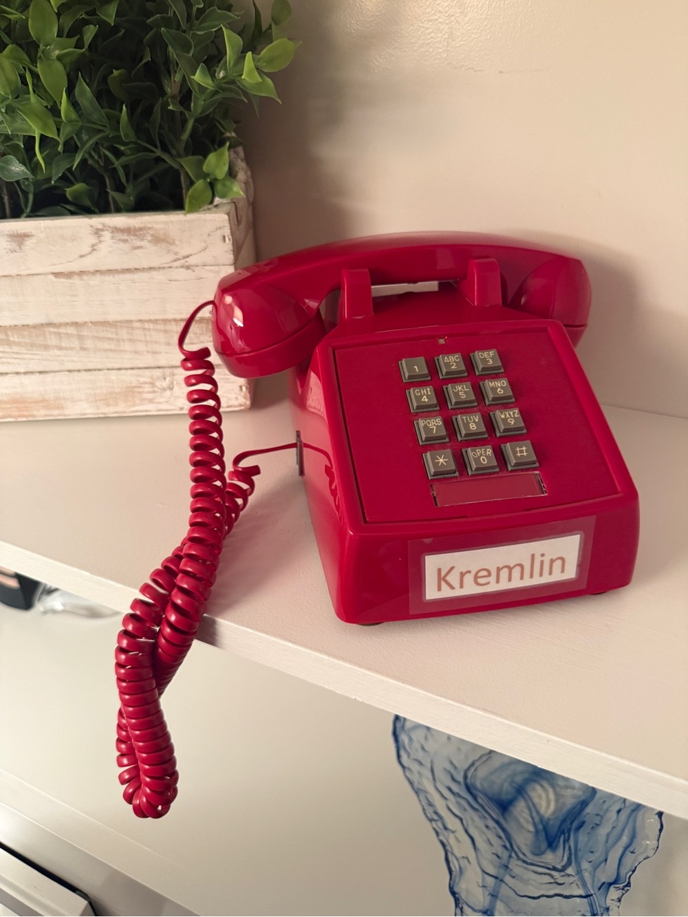 Red ITT Model 2500 push-button desk telephone w/distinctive coiled handset cord.